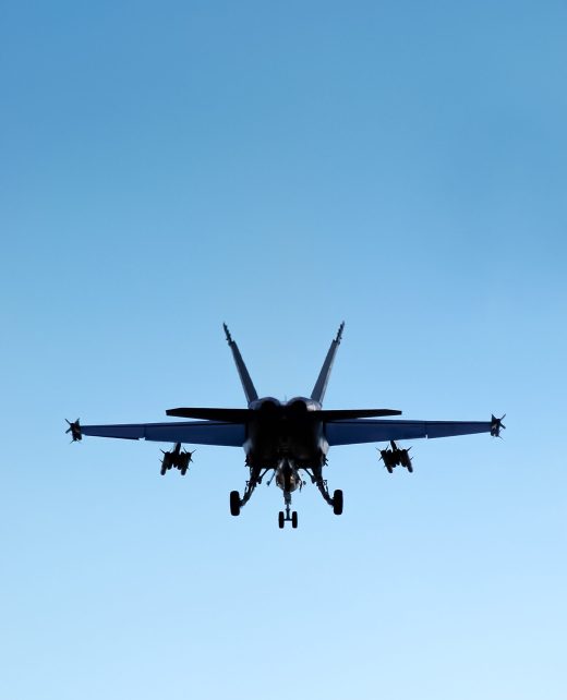 military fighter jet silhouette against blue sky